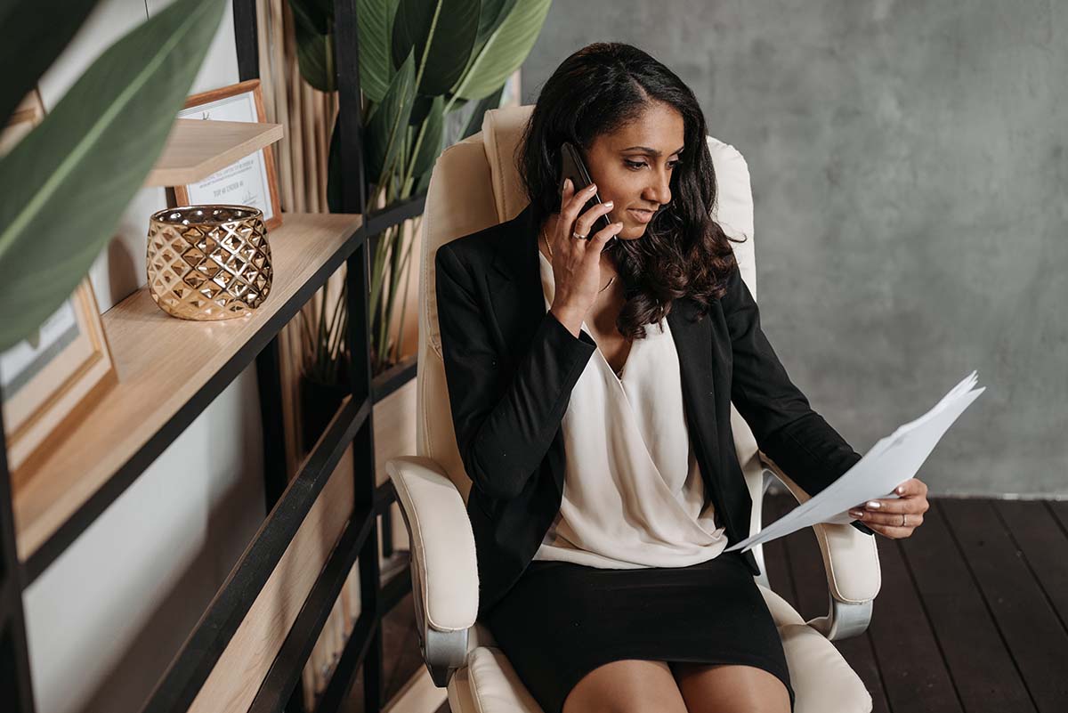 Female Lawyer on Phone While Looking Over Paperwork