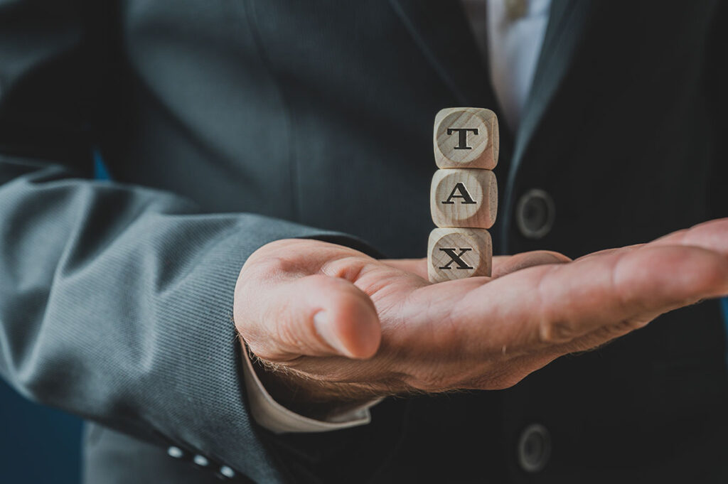 Man Holding Blocks That Spell Tax